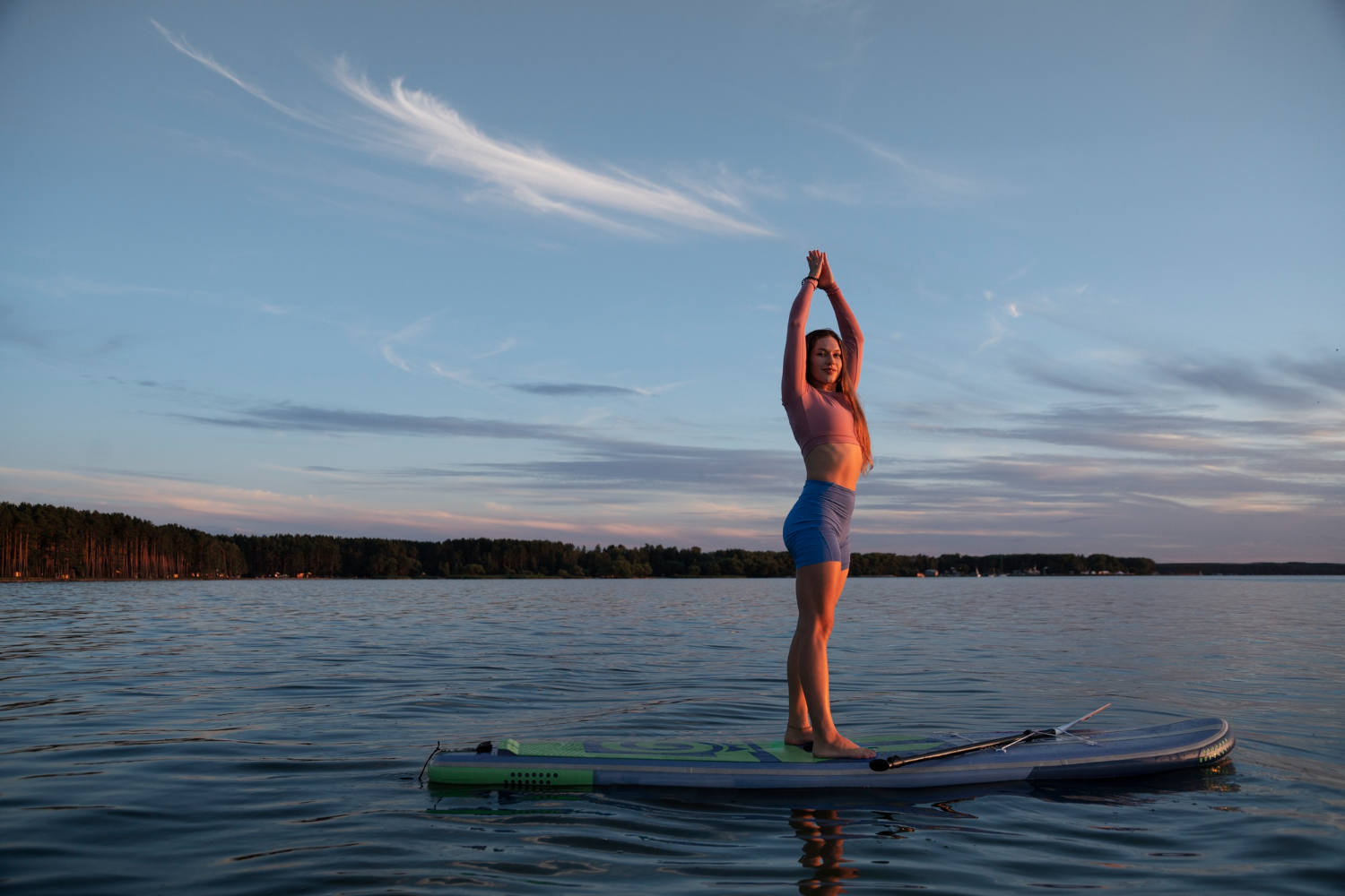 Woman doing yoga on her stand-up paddle